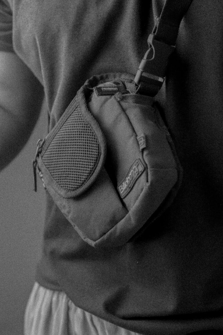 Monochrome close-up of a person wearing a compact shoulder bag.