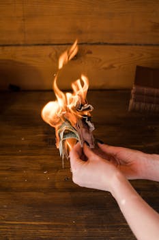 Hands holding burning banknotes against a wooden background, symbolizing financial waste.