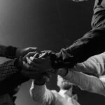 A group of diverse hands united in a gesture of teamwork and collaboration.