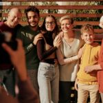 A joyful family portrait featuring multiple generations smiling outdoors in daylight.