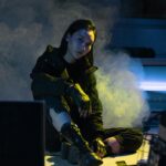 Moody portrait of woman in cyberpunk setting with neon smoke.