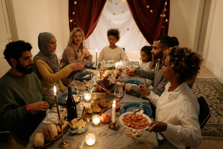 A happy family gathering around a candlelit table for a festive dinner with diverse members.