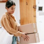 A smiling woman in casual wear delivering packages indoors, showcasing convenience and service.