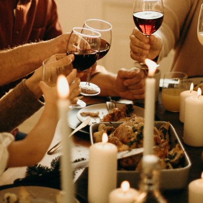 Warm family dinner scene with wine toasting and candlelight ambiance for a festive celebration.